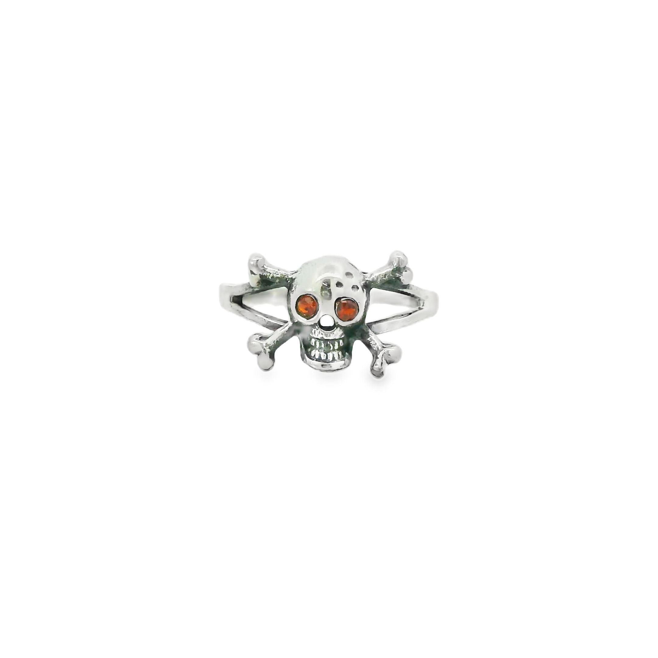 Silver skull and crossbones ring with red eyes on a white background