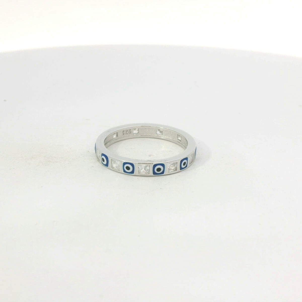 Silver ring with blue evil eye on a white background