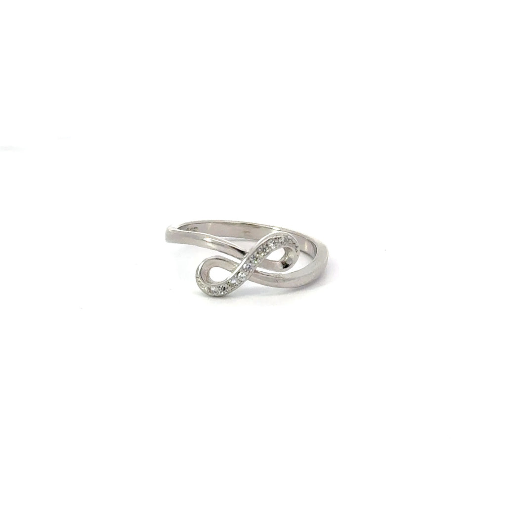 A white cubic zirconia sterling silver ring in an infinity shape design, with the ring positioned diagonally.