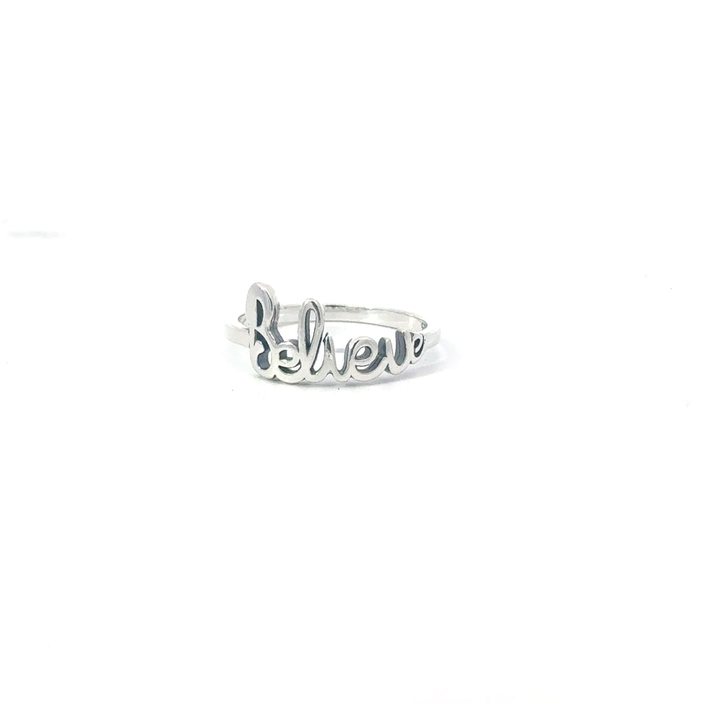 A sterling silver ring with the word 'BELIEVE' stamped on it, displayed on a white background.