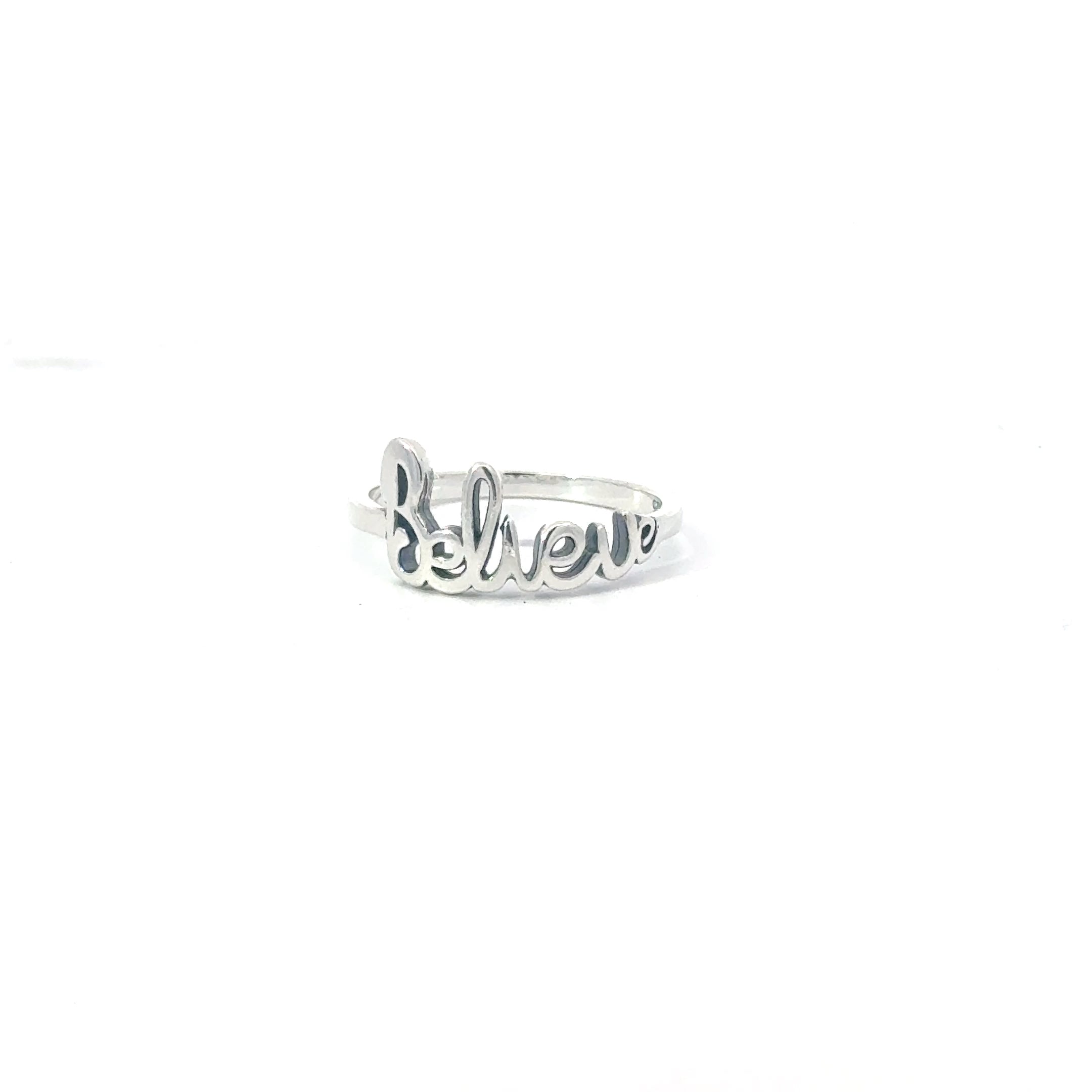 A sterling silver ring with the word 'BELIEVE' stamped on it, displayed on a white background.