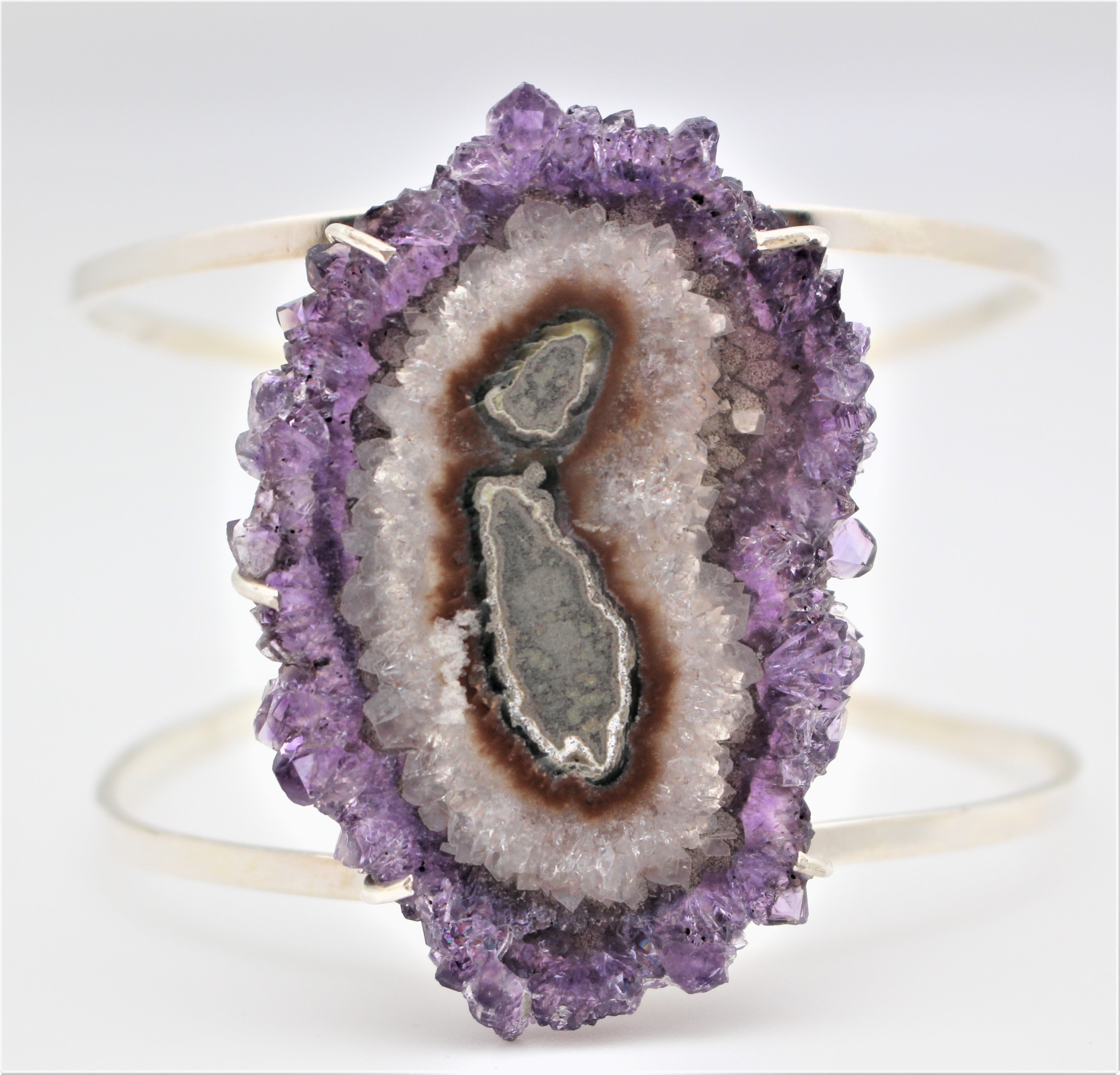 A sterling silver cuff bracelet with a central amethyst geode design.